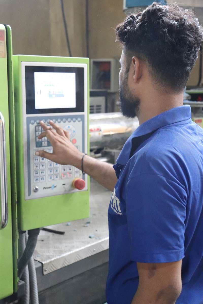 Factory worker at an industrial machine control panel